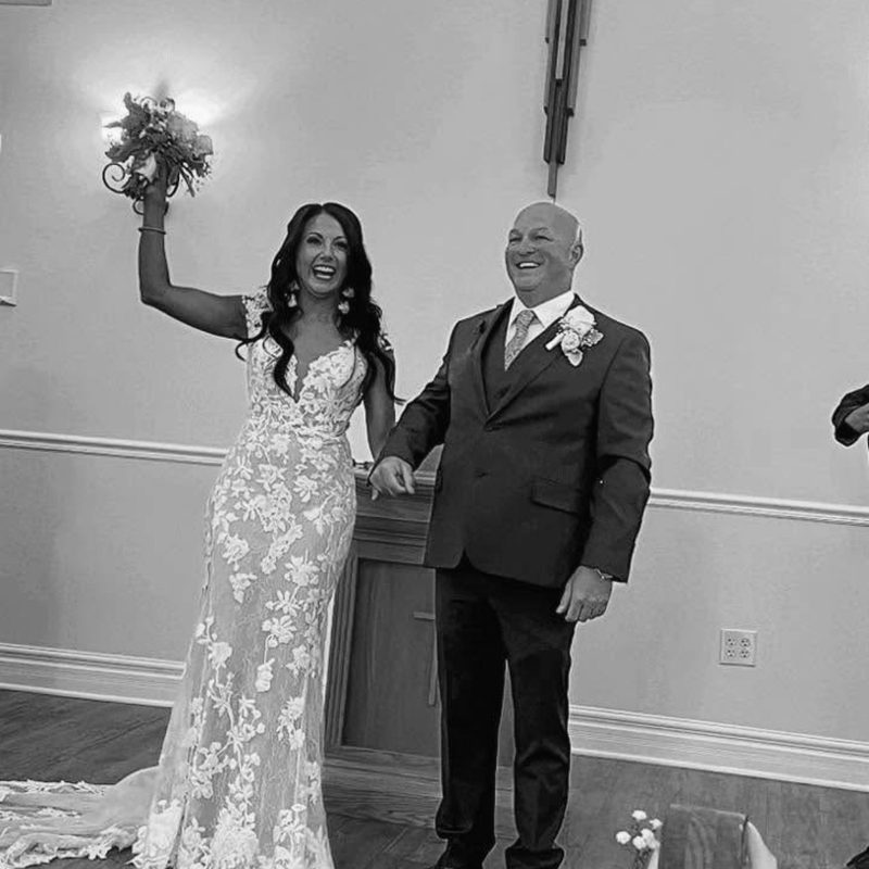 The newlyweds celebrate just after the ceremony, the bride raising her bouquet high
